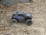 Latrax Teton with brushless upgrade trowing stones in the gravel
